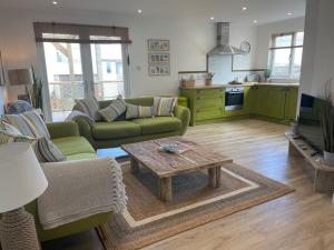 a living room with a couch and a coffee table at Normans Bay Charm The Crabshack Cottage in Pevensey