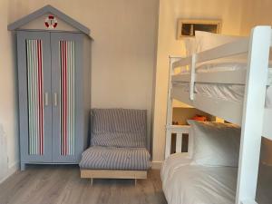 a bedroom with a bunk bed and a chair at Normans Bay Charm The Crabshack Cottage in Pevensey