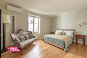 um quarto com uma cama, um sofá e uma cadeira em Appartamento Principe di Belmonte by Wonderful Italy em Palermo