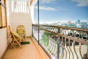 d'un balcon avec des chaises et une vue sur la ville. dans l'établissement Lux Suites 2 Bedroom Diamonte Apartment Ngara, à Nairobi