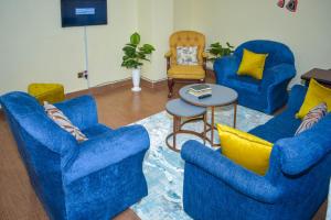 - un salon avec des chaises bleues et une table dans l'établissement Lux Suites 2 Bedroom Diamonte Apartment Ngara, à Nairobi