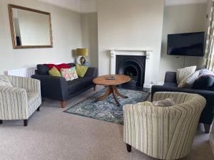 a living room with two couches and a table at Spacious 4-Bed Beach Retreat for Families Steps from the Shore in Pevensey Bay in Pevensey