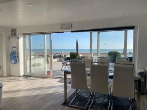 a dining room with a table and a view of the ocean at Coastview Bungalow in Pevensey