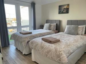 2 nebeneinander sitzende Betten in einem Schlafzimmer in der Unterkunft Beachfront Bliss Stylish Retreat in Pevensey