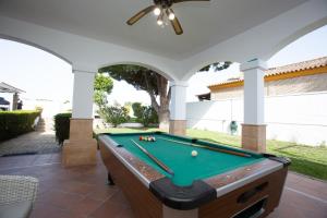 una mesa de billar en un patio cubierto con piscina en Villa las Raices, en Sanlúcar de Barrameda