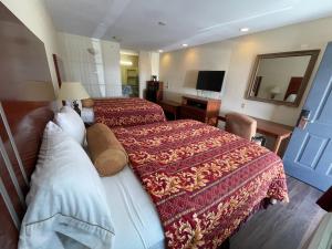 a hotel room with two beds and a television at Riviera Inn and Suites in Riviera