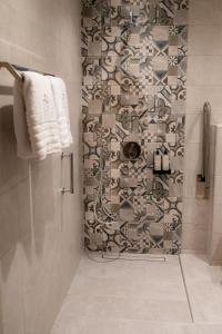 a bathroom with a shower with a tile wall at Nissos Apartments in Myrina