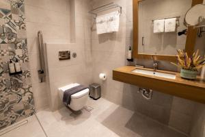 a bathroom with a toilet and a sink and a shower at Nissos Apartments in Myrina