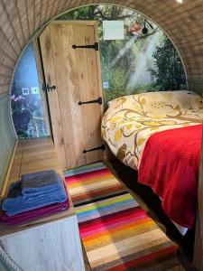 a small room with a bed and a colorful rug at Owl Hollow in Llansantffraid-ym-Mechain