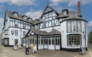 ein großes weißes Gebäude mit zwei Hunden davor in der Unterkunft White Lion Royal Hotel in Bala