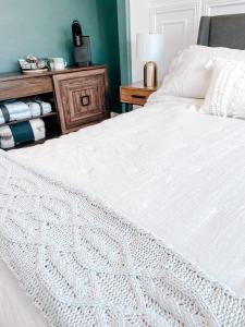 1 dormitorio con cama blanca y mesa de madera en SunStar Alaska Bed and Breakfast LLC en Anchorage