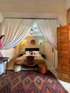 a bedroom with a bed with a large window at Riad Les Miroirs in Marrakech