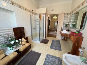 a bathroom with a couch and a shower and a sink at Residenza Porta Brescia in Peschiera del Garda
