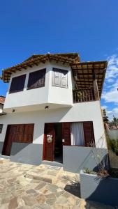 a white house with red doors and a stone yard at Pousada Brisa do Leste in Paraty