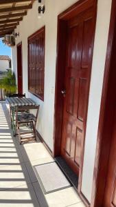 an open door of a house with a table and bench at Pousada Brisa do Leste in Paraty