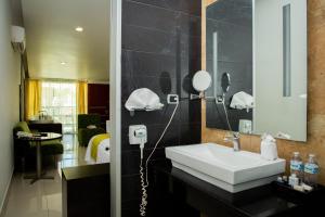 y baño con lavabo blanco y espejo. en Hotel María Dolores San Luis Potosí, en San Luis Potosí