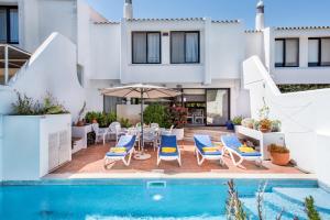 una villa con piscina e una casa di Victory Village Beach Villa - Quinta do Lago a Quinta do Lago