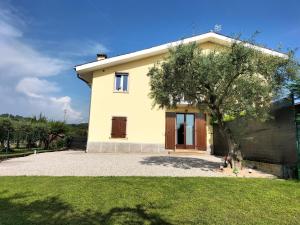 uma casa com uma árvore em frente em Casa Degli Ulivi em Lazise