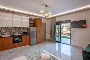 a kitchen with white cabinets and a stove top oven at Olia seaside residence 120m from the beach in Pefkochori