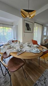 uma mesa de madeira com cadeiras e uma sala de jantar em Good Life à Strasbourg em Estrasburgo
