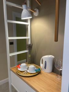 a table with a plate and cups and a lamp at Etna Petit Relais in Nicolosi