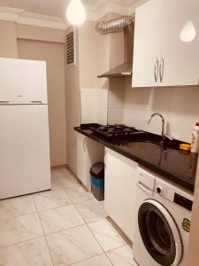 a kitchen with a sink and a washing machine at Pelitpark Apart in Pelitli