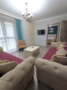 a living room with two couches and a tv at Pelitpark Apart in Pelitli