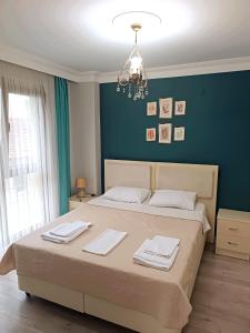 a bedroom with a large bed with a blue wall at Pelitpark Apart in Pelitli