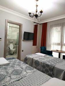 a hotel room with two beds and a flat screen tv at Pelitpark Apart in Pelitli