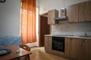 a kitchen with wooden cabinets and a table with a tableablish at Visté Salerno in Salerno