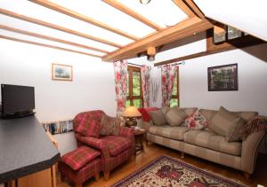 a living room with a couch and two chairs at Corner Barn in North Burlingham