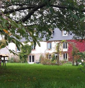 a house with a green lawn in front of it at Gite NATURALLY CALM in Montbray