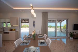 een keuken en eetkamer met een tafel en stoelen bij Villa Kalliestia, sea view veranda and garden in Kissamos