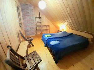 ein Schlafzimmer mit einem Bett und einer Bank im Dachgeschoss in der Unterkunft Pod Bieszczadem in Jaśliska