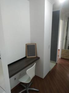 Cette chambre comprend un bureau avec une chaise et un ordinateur portable. dans l'établissement Apartamento Relaxante próximo ao aeroporto, à São José dos Pinhais