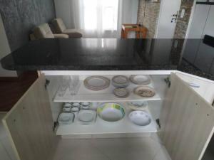 une cuisine avec un comptoir avec des bols et des assiettes dans l'établissement Apartamento Relaxante próximo ao aeroporto, à São José dos Pinhais