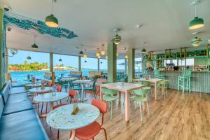 un restaurante con mesas y sillas y vistas al agua en Bocas Paradise Hotel, en Bocas Town