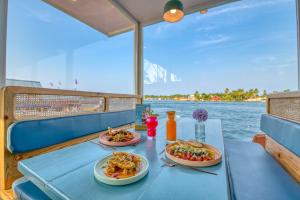 a table with two plates of food on a boat at Bocas Paradise Hotel in Bocas del Toro
