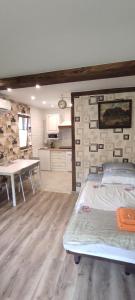 a bedroom with a bed and a table and a kitchen at Apartamenty z ogrodem nr 3 studio z tarasem in Mrągowo