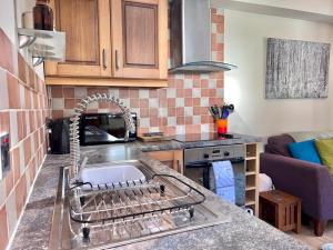 a kitchen with a sink and a counter top at Pass the Keys The Pumphouse Holiday Cottage in Kidwelly