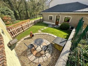 a backyard with a patio with a table and a bench at Pass the Keys The Pumphouse Holiday Cottage in Kidwelly