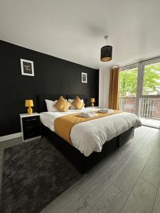 a bedroom with a large bed with a black wall at Relocators - Parking - Central in Birmingham