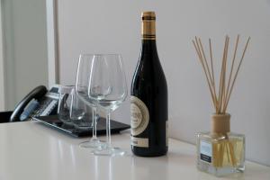 a bottle of wine and two wine glasses on a table at Hotel Blue Sky in Sarandë