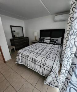 a bedroom with a bed with a checkered blanket at Caribbean Island Retreat in Carolina