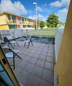 a patio with chairs and a white fence at Caribbean Island Retreat in Carolina