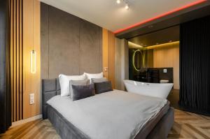 une chambre avec un grand lit et une baignoire dans l'établissement LupoApartments Premium z Klimatyzacją, Wanną w Sypialni Manufaktura Parking Dostęp na Kod, à Łódź