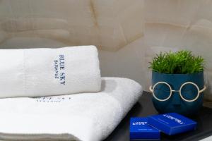a table with towels and a pair of glasses at Hotel Blue Sky in Sarandë