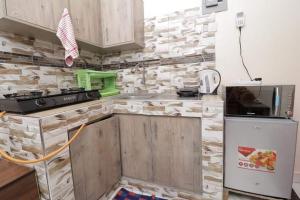 cocina con armarios de madera y encimera en Lux Suites Ganjoni Studio Apartment en Mombasa