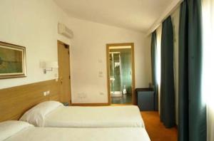מיטה או מיטות בחדר ב-Albergo Al Caminetto