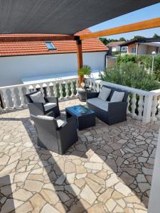 a patio with chairs and a table on a stone patio at Apartment Relax in Vir